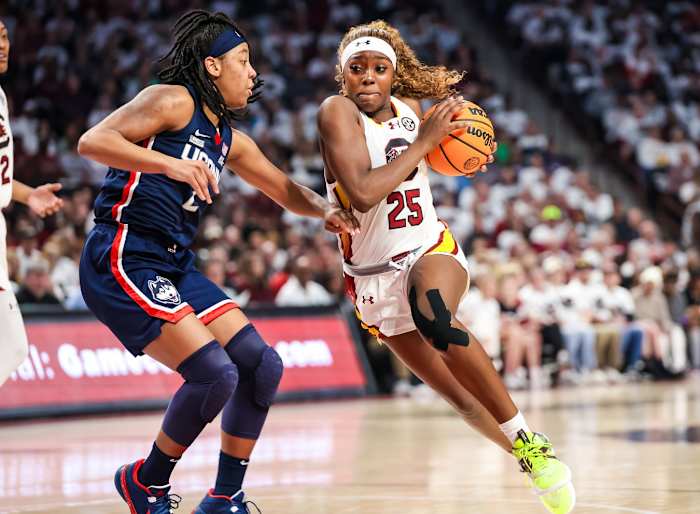 Feb 11, 2024; Columbia, South Carolina, USA; South Carolina Gamecocks guard Raven Johnson (25) drives around UConn Huskies guard KK Arnold (2) in the first half at Colonial Life Arena.